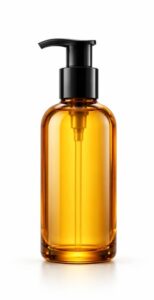 Amber-tinted glass bottle of body or hair oil with black pump, centred on white
