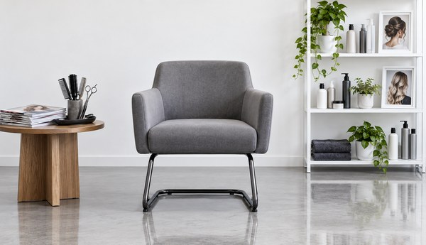 Single salon styling chair in a bright minimalist room with a stack of hair magazines and a small shelf of hair products