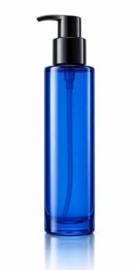 Tall slim blue-tinted glass pump bottle of cleanser or toner, unlabelled, on white