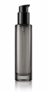 Tall slim grey-tinted glass pump bottle of hair care serum, unlabelled, on white