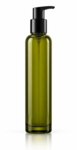 Tall slim olive-green tinted glass pump bottle of body oil, unlabelled, on white