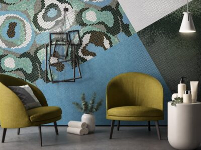 Two olive-green salon armchairs against a blue and green mosaic wall with a styling product display on a white side tabl