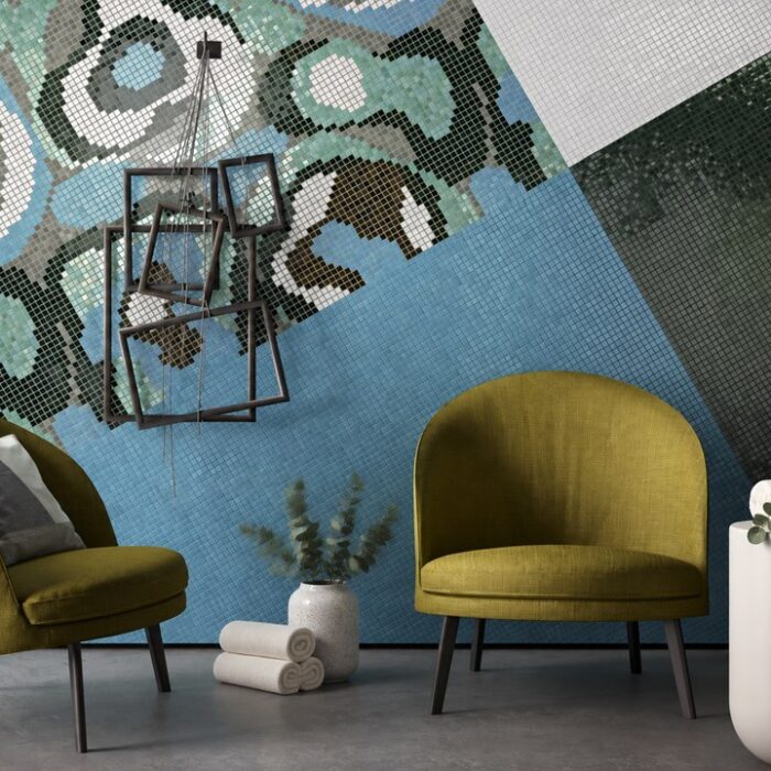 Two olive-green salon armchairs against a blue and green mosaic wall with a styling product display on a white side tabl