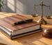 Close-up of a legal document, fountain pen and brass scales of justice on a wooden desk