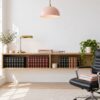 Minimal law office wall with a shelf of leather-bound law books, a lawyer's desk and a black office chair