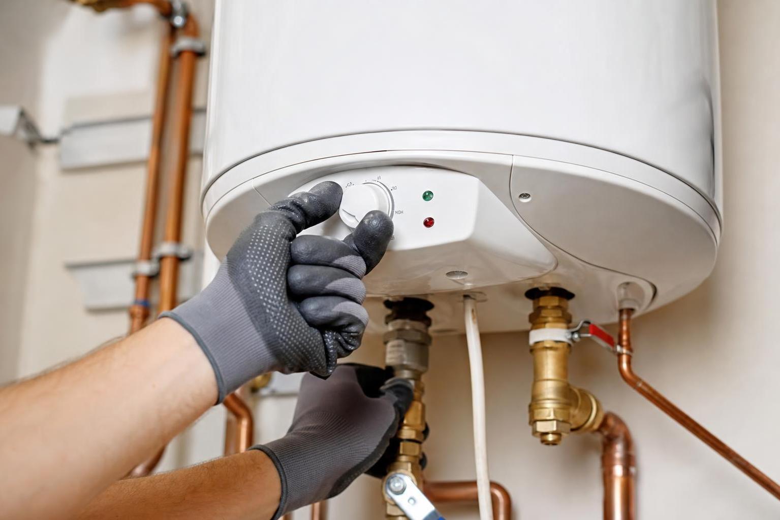 A plumber servicing an electric geyser installation