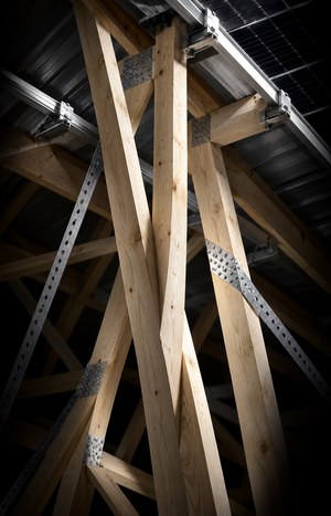 Vertical close-up of roof trusses and cross-bracing supporting solar panel rails